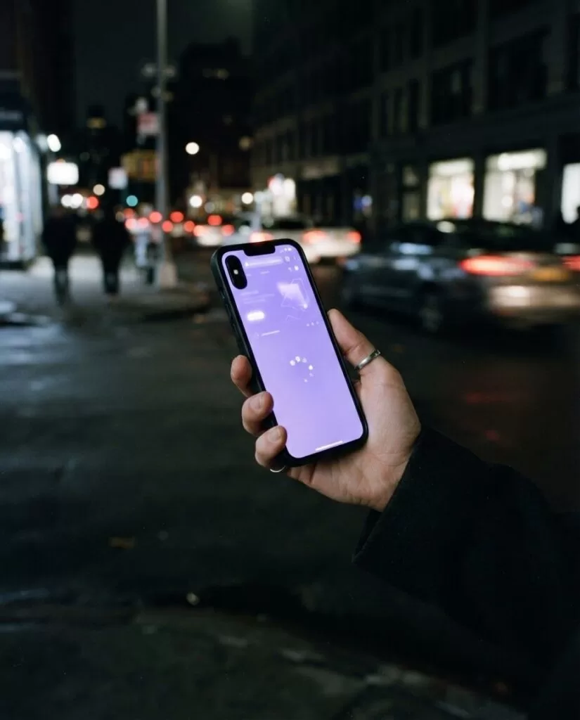 Celular cargando una página web al instante en una calle de noche