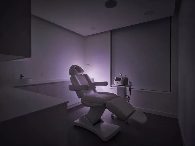 Cabina de un centro de estética con camilla de tratamiento, preparada para reservas online