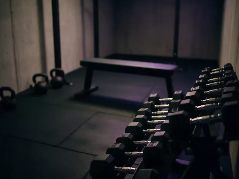 Estudio de entrenamiento personal con mancuernas y banco para clases reservadas online